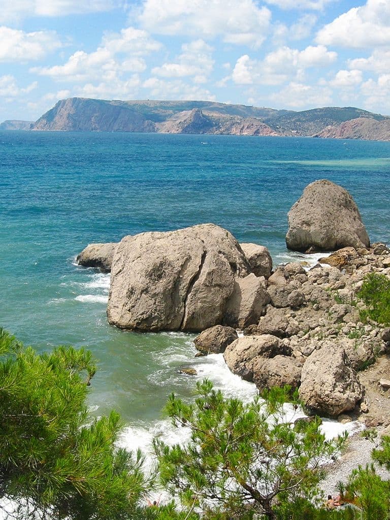 Скалистый берег урочища Аязьма: белые валуны у бирюзовой воды, сосны на склоне, вдали мыс